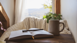Daily journal prompts for a peaceful morning journaling practice with an open journal, pen, and coffee by a sunny window.