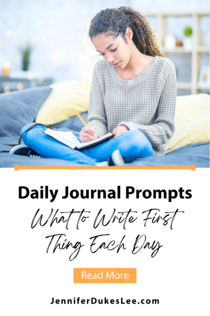 Daily journal prompts for what to write first thing each day, with a woman writing in a journal in the morning.